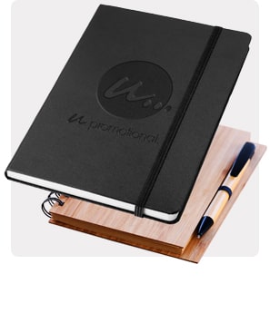 Ein hochwertiges schwarzes Notizbuch mit einem gravierten Logo und ein hochwertiges Notizbuch aus Bambus mit einem Stift