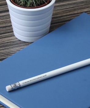 Bedruckter Bleistift mit Radiergummi von Maxilia liegt auf einem Notizbuch