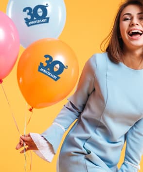 Frau hält günstige Luftballons mit Logoaufdruck