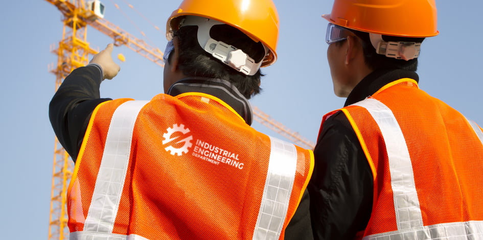 Zwei Bauarbeiter mit orangenen Warnwesten von Maxilia bedruckt mit Logo auf dem Rücken